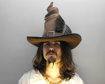 May include: A person wearing a brown leather hat with a tall, pointed crown and a wide brim. The hat has a feather detail on the side.
