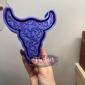 Puede incluir: Un molde de cráneo de toro impreso en 3D de color morado y azul con un diseño floral. El molde está hecho de resina y es perfecto para hacer manualidades de resina.