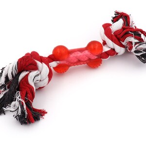 May include: Red, white, and black rope dog toy with a red rubber bone in the center.