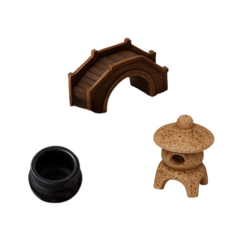 May include: Miniature zen garden decor set featuring a brown wooden bridge, a black ceramic pot, and a tan stone lantern. The bridge has a curved arch and a slatted walkway. The lantern has a domed top and a round opening.