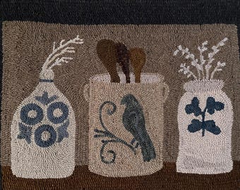 May include: A hand-hooked rug featuring three decorative jars. The jars are filled with wooden spoons, branches, and flowers. The rug has a neutral color palette with a black border.