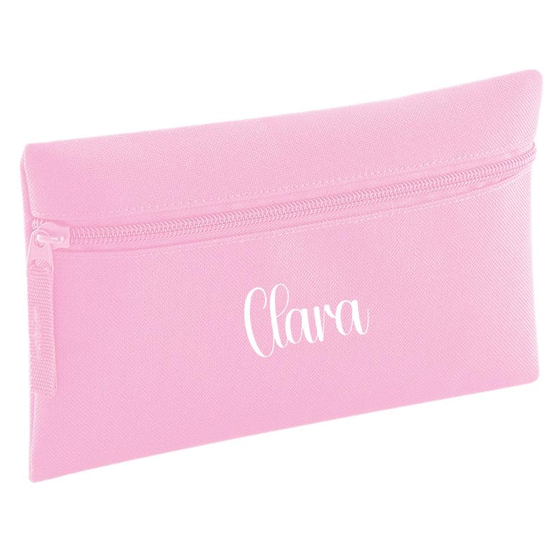 Personalised classic pink pencil case with zip closure, customised with a child's name in white vinyl. Durable 600D polyester school pencil case for pens, pencils and stationery, ideal for school, nursery and back to school essentials.