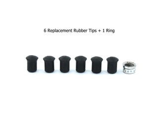 May include: Six small black cylindrical rubber tips arranged in a horizontal row next to a single silver-colored metal ring with a perforated edge. The text 6 Replacement Rubber Tips + 1 Ring is positioned above the items.
