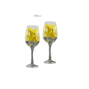 May include: Two clear glass wine glasses with pewter stems and grapevine designs. The glasses are empty and have a yellow napkin inside.