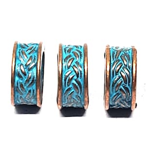 May include: Three cylindrical beads with a turquoise braided design and copper-coloured edges. The beads have a weathered appearance. The braided pattern is detailed, adding texture. Each bead is approximately 1 cm in diameter.