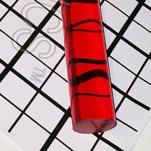 May include: A red and black striped acrylic rod. The rod is about 12 inches long and 1 inch in diameter.