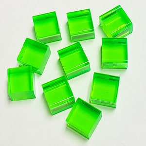 May include: Ten bright green square tiles with bevelled edges. The tiles are made of a translucent material and have a slight sheen.