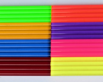 May include: A vibrant, colorful abstract composition featuring rectangular blocks of various colors. The blocks are arranged in a grid pattern, showcasing shades of green, orange, purple, pink, yellow, blue, and red. The surface has a ribbed texture.