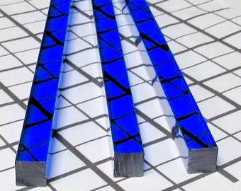 May include: Three blue glass rods with black lines running through them. The rods are square in shape and have a polished finish.
