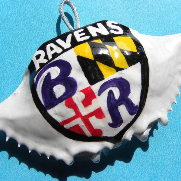 Ravens written top with B and R letters on shield handpainted crab shell ornamentent. Comes in plastic container ready to wrap