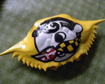 Natty Boh with Maryland flag mustache painted on a crab shell ornament. Packaged in a plastic container with coordinated shred