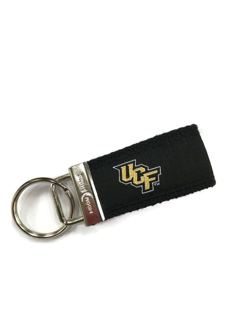 May include: Black key chain with a silver key ring and a black fabric strap with the UCF logo in gold and gray embroidery.