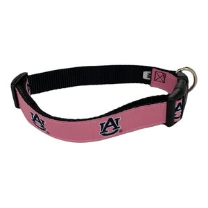 May include: Pink dog collar with a black buckle and the Auburn University logo in navy blue.
