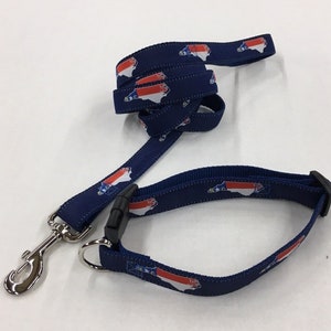 Op de afbeelding: Een blauwe hondenriem en halsband met een herhalend patroon van de staat North Carolina in rood, wit en blauw.