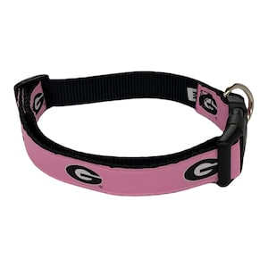 May include: Pink dog collar with a black and white University of Georgia logo.