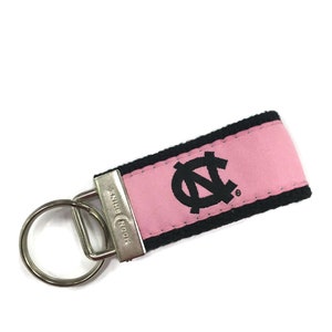 May include: Pink and black key chain with a black embroidered "N" logo and the text "Moonshine" on the metal ring.