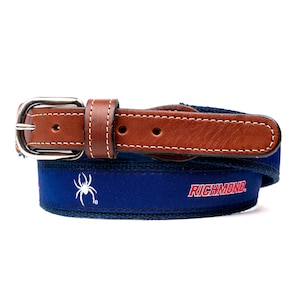 May include: A blue belt with a brown leather strap and silver buckle. The belt features the word "Richmond" in red and a white spider logo.