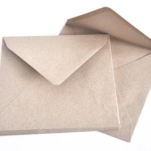 May include: A stack of brown paper envelopes with a flap on the top. The envelopes are made from recycled paper and have a natural, rustic look.