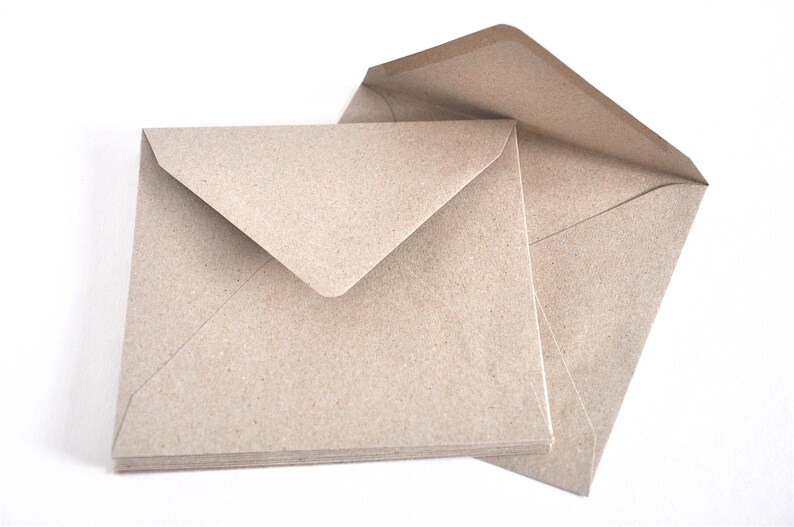May include: A stack of brown paper envelopes with a flap on the top. The envelopes are made from recycled paper and have a natural, rustic look.