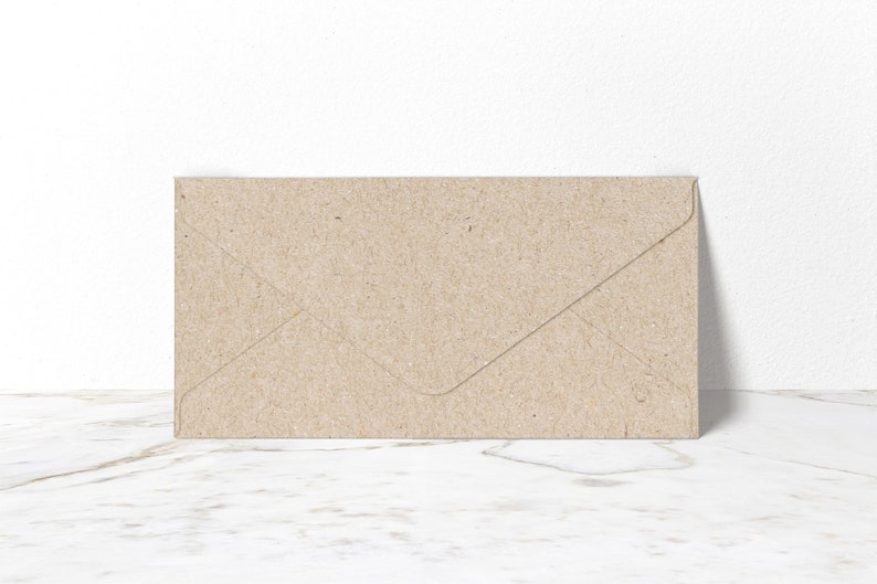 May include: A brown paper envelope with a flap on the top. The envelope is lying flat on a white marble surface.