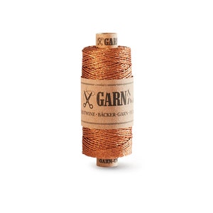 May include: A spool of copper-colored twine with a brown paper label that reads "GARN & TWINE - BÄCKER-GARN -  FRIEDRICHSHAFEN".