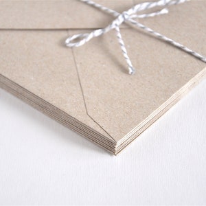 May include: A stack of brown kraft paper envelopes tied together with a white twine string.