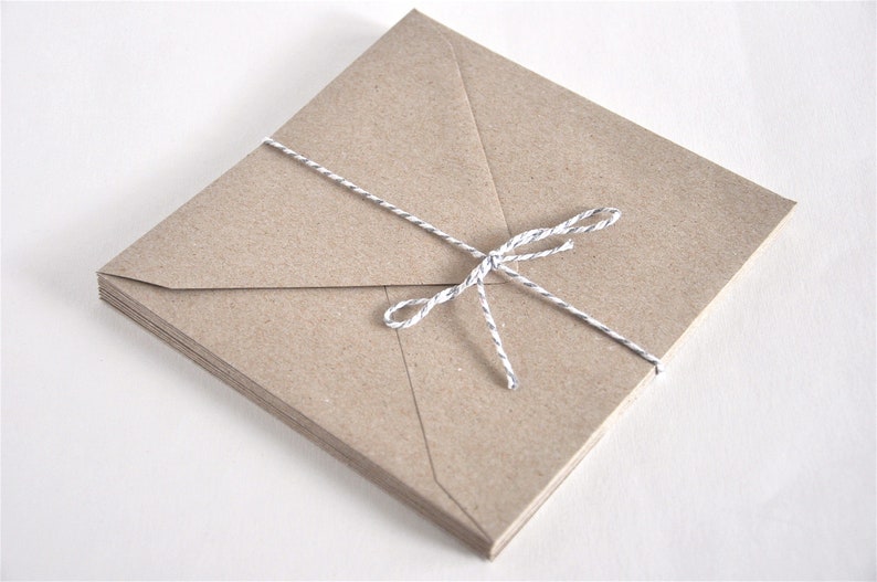 May include: A stack of brown paper envelopes tied together with a white twine string.