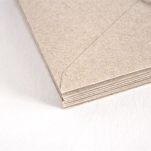 May include: A stack of brown kraft paper envelopes with a white string attached to the top.