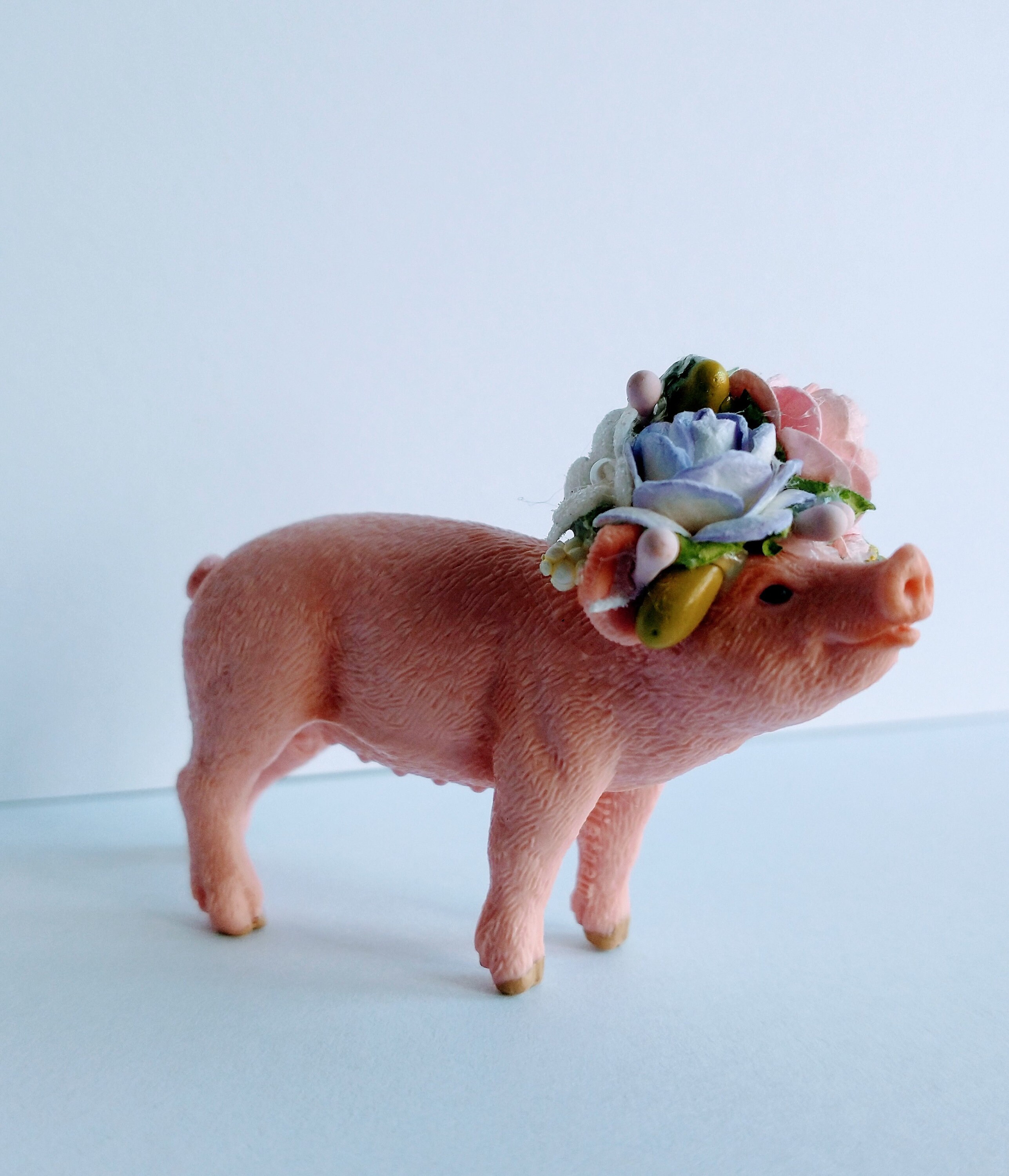 Tortenfigur Schleich Ferkel, mit Blumenkrone, enthält eine personalisierte Mini-Flagge.