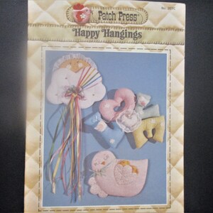 Może przedstawiać: Wzorzec szycia vintage firmy Patch Press do "Happy Hangings". Wzorzec zawiera instrukcje do wykonania chmury, serca, ptaka i innych kształtów. Wzorzec to nr 397C.