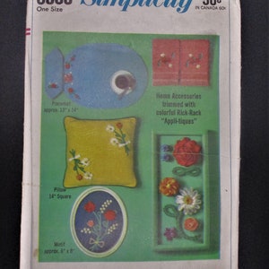 Può includere: Un modello di cucito Simplicity per accessori per la casa, tra cui un sottopiatto, un cuscino e un motivo. Il modello presenta "Appli-tiques" in cordoncino colorato ed è progettato per una sola taglia. Il numero del modello è 6805 e il prezzo è di 50 centesimi.