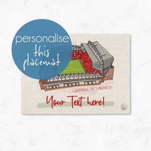 May include: A personalised linen placemat featuring a detailed illustration of Anfield Stadium, home to Liverpool FC. The placemat is beige with green text that says "Your Text here!" and the words "Liverpool FC | Anfield" in black text.