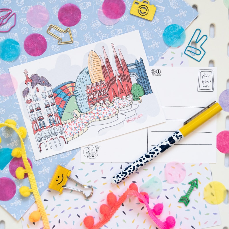 May include: A colorful postcard with a hand-drawn illustration of the Sagrada Familia basilica in Barcelona, Spain. The postcard has a place to put a stamp and an address. The text on the postcard says "Barcelona".