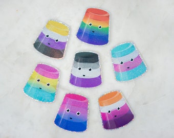 May include: Seven colorful, glittery, layered, jelly cup stickers with cute faces. Each sticker has a different color combination, representing different pride flags.