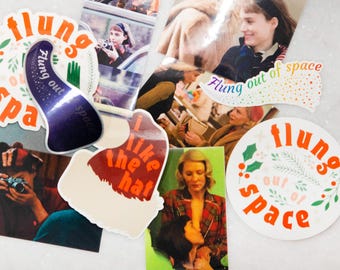 May include: Assortment of colorful stickers with various designs and text, including "Flung out of space" and "I like the hat".