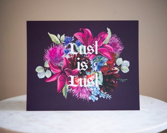 Puede incluir: Una tarjeta morada con un arreglo floral de flores rosas, rojas y azules. El texto "Lust is Lust" está escrito en blanco en la tarjeta.
