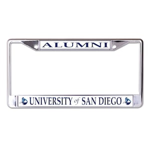 May include: A silver chrome license plate frame with a white background and blue text. The top of the frame says "ALUMNI" and the bottom says "UNIVERSITY of SAN DIEGO" with a small blue logo on each side.