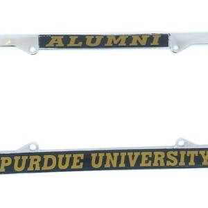 May include: A chrome license plate frame with black and gold lettering that reads "ALUMNI PURDUE UNIVERSITY".