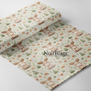 May include: A light green fabric with a repeating pattern of cartoon moose, mushrooms, butterflies, and pine trees. The moose are brown with large antlers, and the trees are green. The fabric is rolled up in the image.