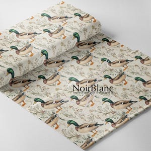 May include: A roll of fabric featuring a repeating pattern of mallard ducks and floral elements in shades of brown, green, and beige. The fabric has a vintage aesthetic, with the text "NoirBlanc" visible.