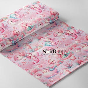 May include: Pink fabric with a repeating pattern of mermaids, sea creatures, and coral. The design includes mermaids, octopuses, dolphins, and sea urchins in shades of pink, blue, and white. The fabric is rolled up on the left side.