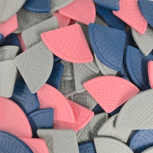 May include: A collection of colorful silicone corner protectors in pink, gray, and blue. The protectors are shaped like a quarter circle and have a textured surface.