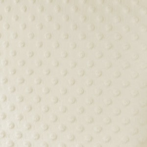 May include: Cream-coloured fabric with a textured surface. The fabric has a pattern of evenly spaced, raised, circular dots. The material appears soft and plush, with a subtle sheen. The overall effect is a simple, yet elegant design.