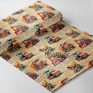 May include: A roll of fabric featuring a repeating pattern of construction vehicles, including dump trucks, excavators, and cement mixers. The vehicles are in shades of orange, green, and gray on a beige background with orange and brown speckles. The fabric has the text "NoirBlanc" on it.