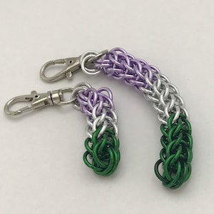 May include: Two keychains made of silver, green, and purple chainmail. The keychains are in the shape of a loop and a teardrop.