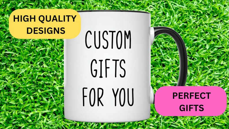 May include: White ceramic mug with a black handle and black rim. The mug has the text "CUSTOM GIFTS FOR YOU" printed on it. The mug is sitting on a green grassy surface. There is a yellow rectangle with the text "HIGH QUALITY DESIGNS" and a pink rectangle with the text "PERFECT GIFTS" on either side of the mug.