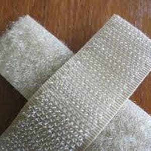 May include: Two strips of beige hook and loop fastener, also known as Velcro. The hook side is on the top and the loop side is on the bottom.