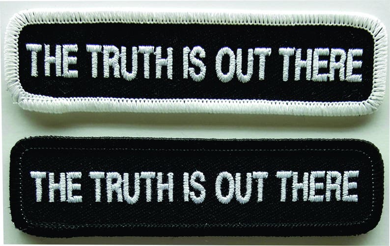 May include: Two black fabric patches with white stitching. Both patches have the text "THE TRUTH IS OUT THERE" in white.