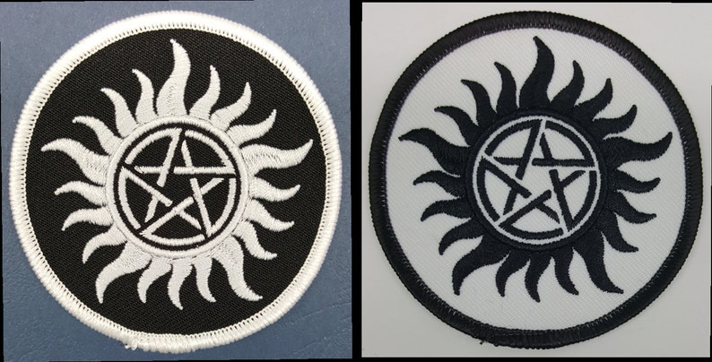 May include: Two round black and white embroidered patches with a pentagram inside a sunburst design. The patches are approximately 3 inches in diameter.