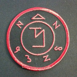 May include: A red embroidered patch with a black background featuring a pentagram symbol, a triangle, and the numbers 1, 2, 3, 8, and 9.